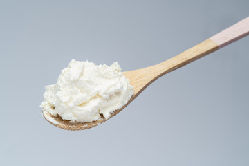 Traditional organic Mascarpone cheese in wooden spoon