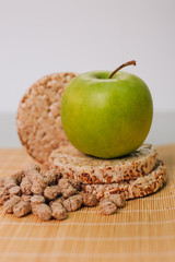Green apple and bran. Healthy food. Diet for weight loss. Dietary bread