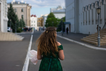 Fototapeta na wymiar young woman in green dress walking on the street