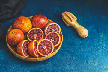 Sicilian Blood oranges in wooden plate and juicer
