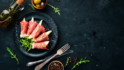 Prosciutto with pear and arugula. Cold snacks. Top view. Free space for your text.