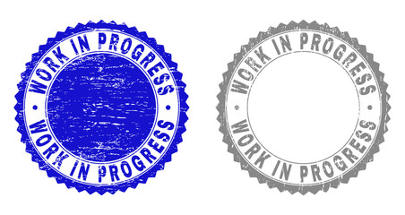 Obraz premium Grunge WORK IN PROGRESS stamp seals isolated on a white background. Rosette seals with grunge texture in blue and grey colors.