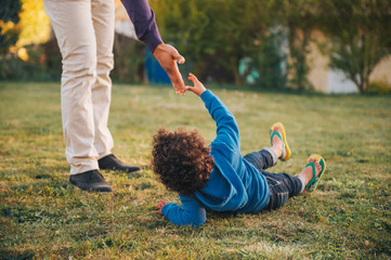 Father giving a helping hand to his son lying on the ground