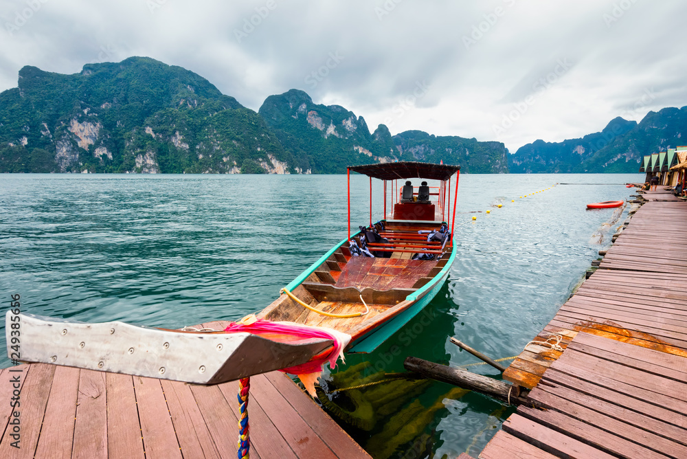 Wall mural long-tailed boat floating on the asia lake and homestay in the among the islands with mountains in b