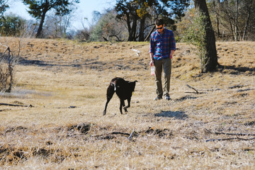 Fototapeta na wymiar Man with pet dog in rural outdoors. Happy country lifestyle image.