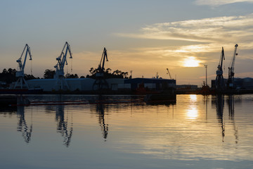 Fototapeta na wymiar harbor cranes at sunset