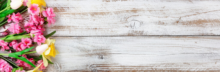 Springtime flowers on white rustic wooden background for seasonal holidays like Easter and Mothers Day