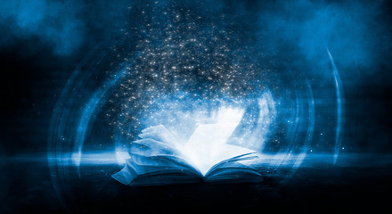 The book is open, magical glow, rays of light. 