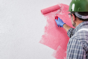 Professional house painter at work painting the wall © francescomou