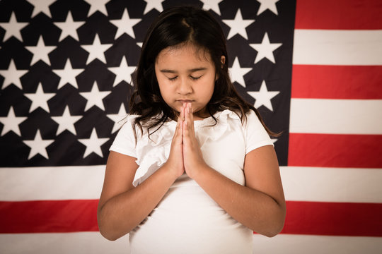 Young Girl Praying by American Flag