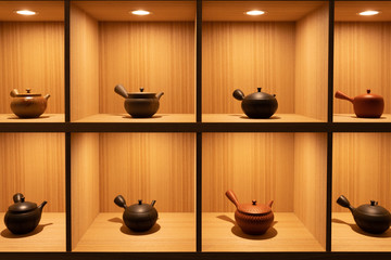 Traditional Japanese pots used for tea ceremony on grid shelves