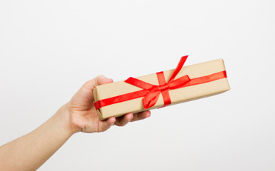 hand holding small red present box in hands isolated