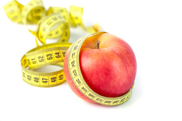 Red apple with measure tape on white background, healthy diet