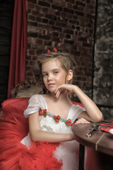 young princess in a red and white dress sitting