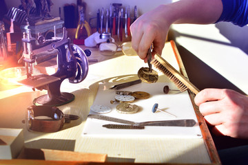 Watchmaker repairs watch in workshop. Workplace of watch repairer. Process of repair mechanical...