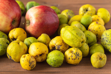 Fresh organic quince and apples from the garden on a wooden table.
