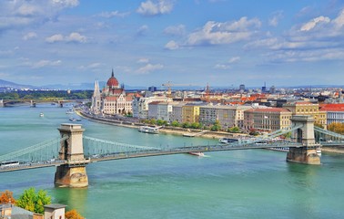 Obraz premium Incredible spectacular picturesque view of Hungarian Parliament and chain bridge in Budapest, Hungary. Panorama cityscape of famous tourist destination Budapest with Danube, parliament and bridges.