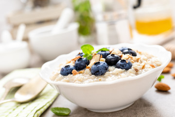 Oatmeal with fresh blueberry, almond nuts and honey for breakfast