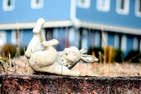 Stone rabbit lying on wall in laughing postion