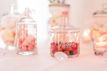 Jar filled with colorful candies, pastel roses and succulents