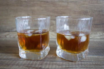 Whiskey. Glass of whiskey with ice, bourbon on a wooden background. Scotch in a glass. Alcoholic drink