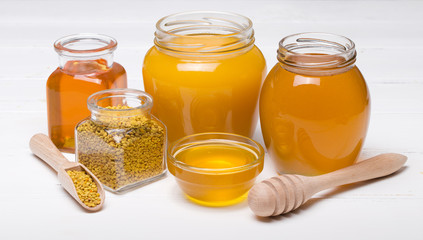 honey dipper and honey in jar on white background