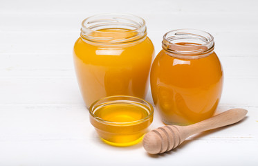honey dipper and honey in jar on white background