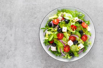 Poster Vegetable salad with fresh cucumber, tomato, olive, onion, lettuce and feta cheese. Healthy food. Top view © Sea Wave