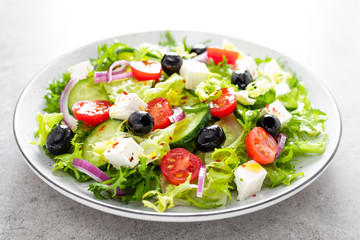 Vegetable salad with fresh cucumber, tomato, olive, onion, lettuce and feta cheese. Healthy food