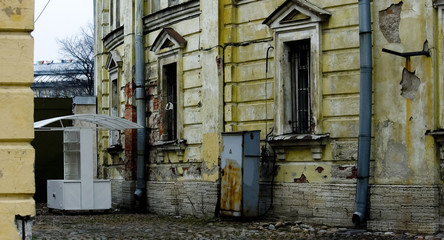 Facade of a classicism yellow abandoned building with pylons in Saint-Petersburg, Russia