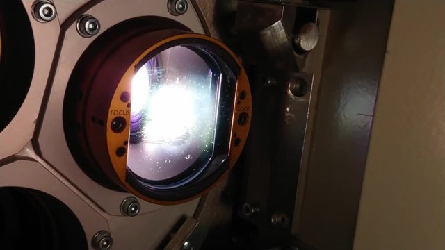 The lens of a cinema projector in a movie theater - close up view