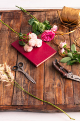 The workplace of the florist to work. Side view. Making floral decorations. Flowers on a old wooden table. Tools and accessories florists need for making up a bouquet.