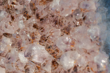Amethyst natural crystal cluster with Goethite inclusions from Brazil on white snow at a sunny winter day.