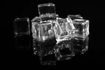 Pile of crystal clear ice cubes on black background