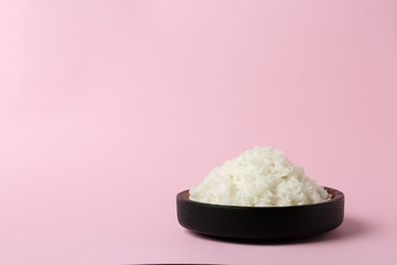 Bowl of boiled rice on color background. Space for text