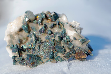 Calcite Cluster Points covered with Pyrite on white snow at a sunny winter day.