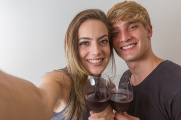 Beautiful loving couple taking a selfie with his smartphone. Celebrating Saint Valentine's Day.