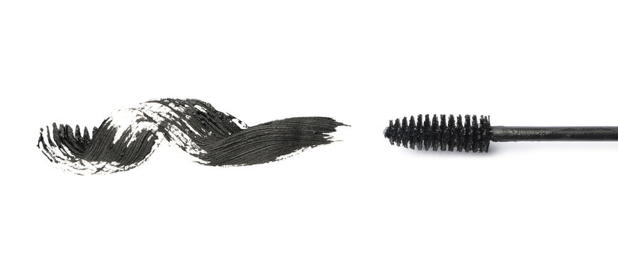 Applicator and black mascara smear for eyelashes on white background, top view
