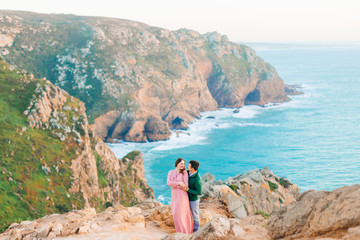 husband and wife hug on the shore of the evening ocean. rocky co
