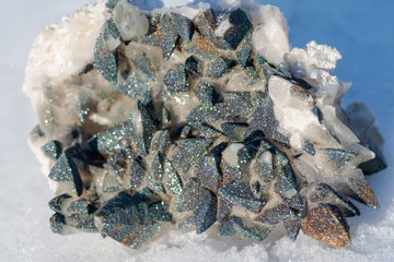 Calcite Cluster Points covered with Pyrite on white snow at a sunny winter day.