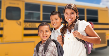 Young Hispanic Girl and Boys Walking Near School Bus