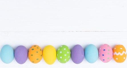 Easter eggs concept. Happy Easter Day. Row Easter eggs on white wooden background.