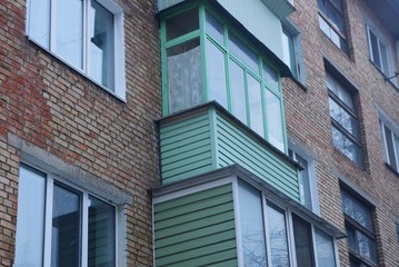 a row of balconies and windows on the brown wall of an old house