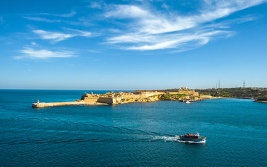 Grand Harbour in Valletta city. Red Lighthouse and tourist boat. Fort Ricasoli. Malta country....