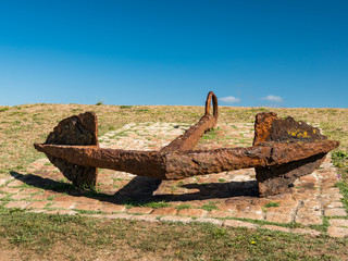 A big rusty anchor lying on the ground