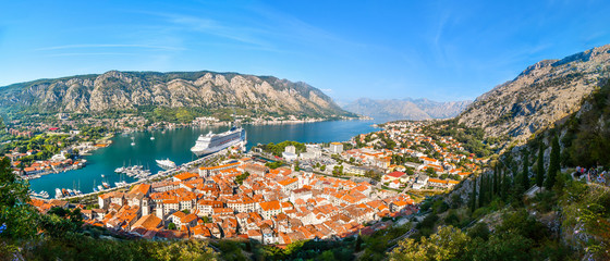 A panoramic view of the Bay of Kotor, cruise port, mountains and the medieval walled old town from the ruins of the Castle of San Giovanni - obrazy, fototapety, plakaty