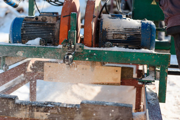 Sawing boards on the sawmill. Cook lumber in winter. Work on the sawmill.