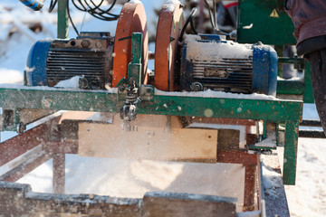 Sawing boards on the sawmill. Cook lumber in winter. Work on the sawmill.