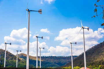 Wind turbines farm eco field in bright day with blue sky background at Chang Hua Man Royal Projects Phetchaburi Thailand.