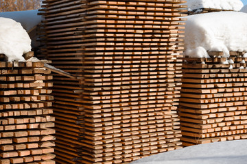 Timber lies under the snow. Sawn timber layzima.